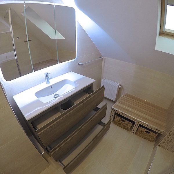 A présent, il y a des zones de rangement dans cette petite salle de bain en sous pente !